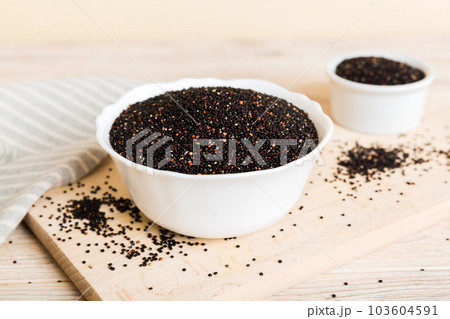 quinoa seeds in bowl on colored background. Healthy kinwa in small bowl. Healthy superfood quinoa seeds in bowl on colored background. Healthy kinwa in small bowl. Healthy superfood 103604591