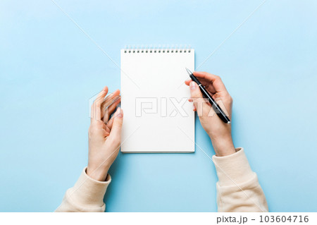 Woman hand with pencil writing on notebook. Woman working on office table. Female hand holding pencil and sketchbook. Mock-up Concept 103604716