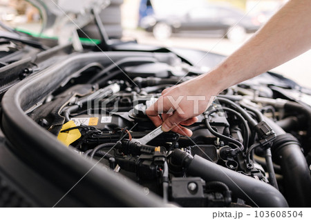 Auto mechanic working in garage. Human hands hold tools. Repair service concept Auto mechanic working in garage. Human hands hold tools. Repair service concept 103608504