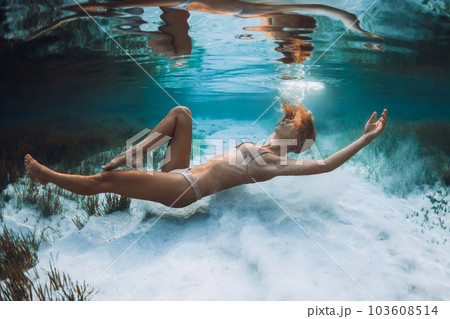 Blonde woman fun and swim underwater in transparent ocean in Bali Blonde woman fun and swim underwater in transparent ocean in Bali 103608514