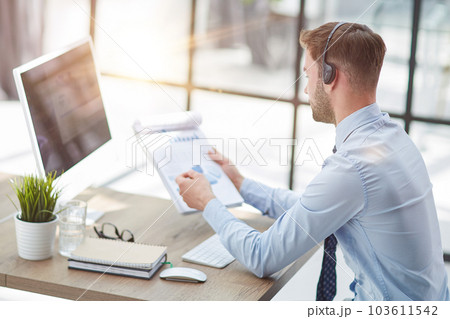 Man with headphones and laptop working in office Man with headphones and laptop working in office 103611542