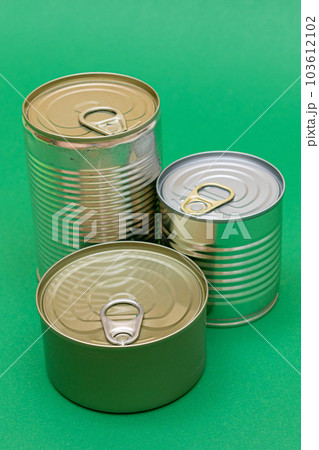 Unopened Tin Cans with Blank Edges on Green Background 103612102