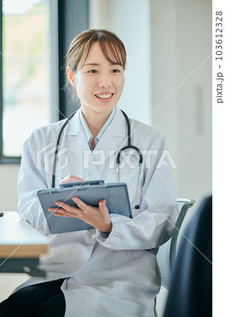 患者に問診をする若い女性医師 患者に問診をする若い女性医師 103612328