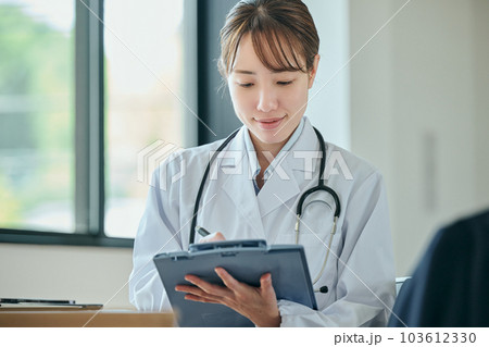 患者に問診をする若い女性医師 患者に問診をする若い女性医師 103612330