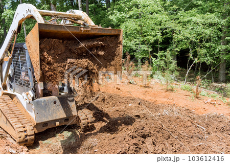 Planning work site on improvement of tractor prepares courtyard territory for construction 103612416