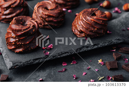 cakes in chocolate glaze on stone board 103613370