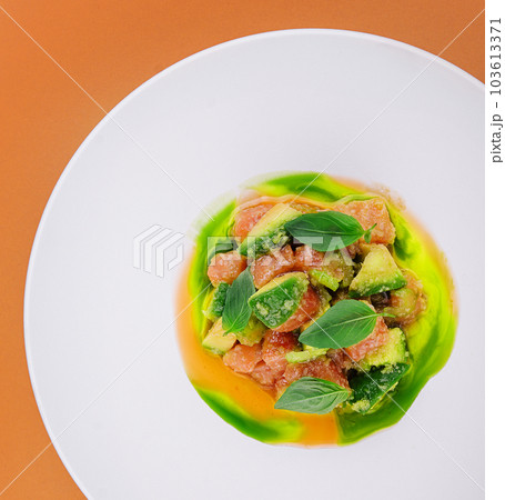 salmon with avocado and basil on white plate 103613371
