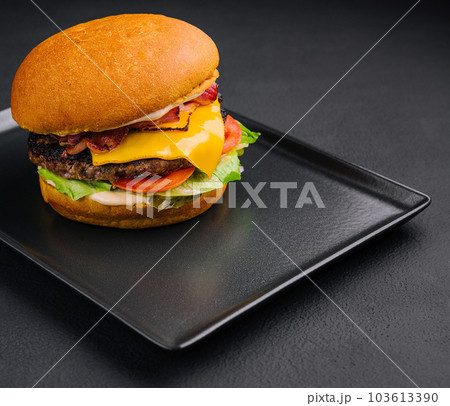 Close up tall tasty burger with cheese served on tray 103613390