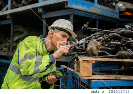Engineering man worker wear uniform and helmet using tablet checking automotive parts in warehouse. Engineering man worker wear uniform and helmet using tablet checking automotive parts in warehouse. 103613515
