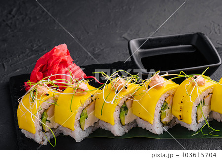Vegan yellow maki sushi rolls on stone 103615704