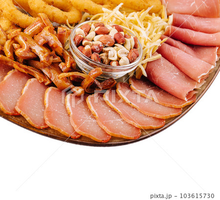 Dried beef, fried pig ears, onion rings, calamari, nuts, on a plate 103615730