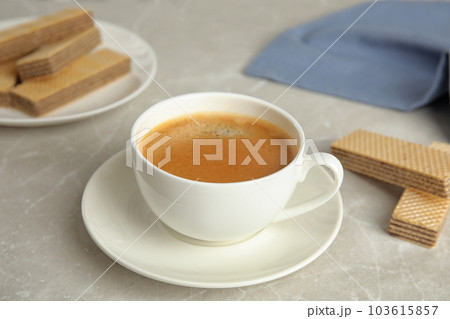 Delicious coffee and wafers for breakfast on grey marble table Delicious coffee and wafers for breakfast on grey marble table 103615857