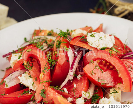 Purple chopped onions lie on goat cheese in a vegetable salad 103615970
