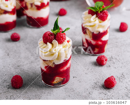 Layered dessert Trifle with vanilla cake, whipped cream and fresh raspberries 103616047