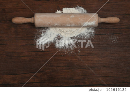Flour and rolling pin on wooden table, top view. Space for text Flour and rolling pin on wooden table, top view. Space for text 103616123