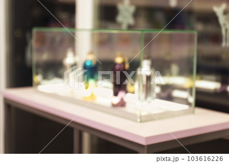 Blurred view of perfume bottles on stand in shop 103616226
