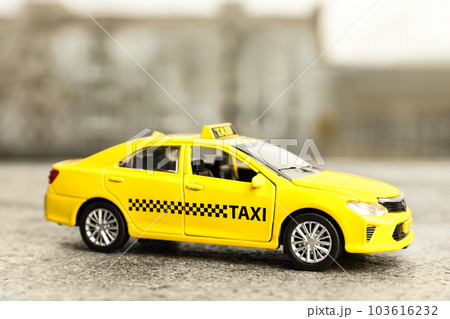 Yellow taxi car model on city street 103616232