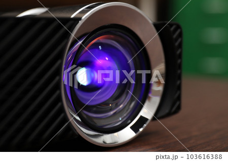 Closeup view of modern digital video projector on table 103616388