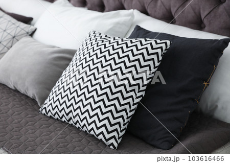 Soft pillows on modern bed in room 103616466