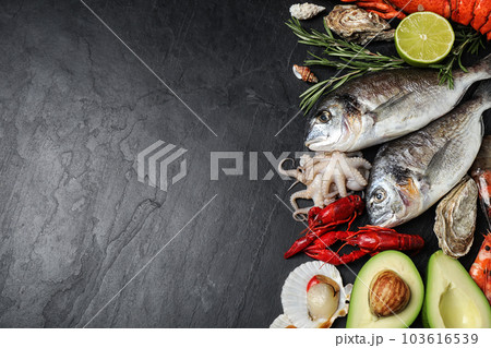 Fresh fish and different seafood on black table, flat lay. Space for text 103616539