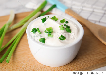 Fresh sour cream with onion on wooden board, closeup 103616583