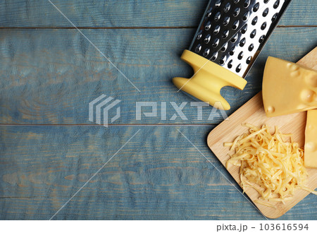 Tasty grated cheese on blue wooden table, flat lay. Space for text Tasty grated cheese on blue wooden table, flat lay. Space for text 103616594