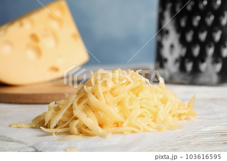 Tasty grated cheese on white wooden table, closeup Tasty grated cheese on white wooden table, closeup 103616595