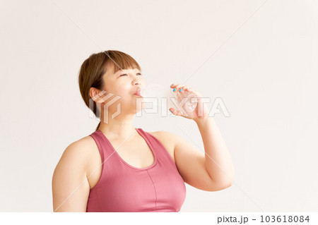 水分補給をするぽっちゃり体型の若い女性　プラスサイズモデル　イメージ 103618084