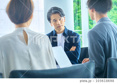 オフィスで打ち合わせする男女のビジネスチーム 103618698