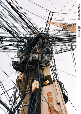 Large coils of wires and cables on a pole, the chaos of Asian power lines. 103620265