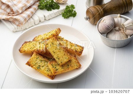 Crispy Garlic Bread on white plate.Air fryer bread with butter garlic and parsley.Snack food Crispy Garlic Bread on white plate.Air fryer bread with butter garlic and parsley.Snack food 103620707