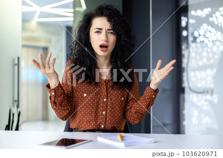Angry and angry business woman inside office at workplace, latina woman yelling at camera, boss talking displeased with employees remotely online meeting video call. 103620971
