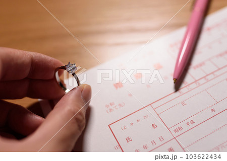 婚姻届と手に持った結婚指輪　婚約指輪　元号令和の書類 103622434