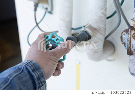 給水バルブを操作する作業員 103622522