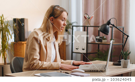 Businesswoman working on laptop wearing headset call center support service operator office helpline 103624045