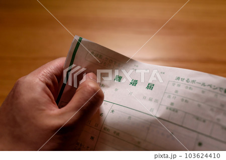 離婚届をくしゃくしゃに握りしめる男性の手 離婚届をくしゃくしゃに握りしめる男性の手 103624410