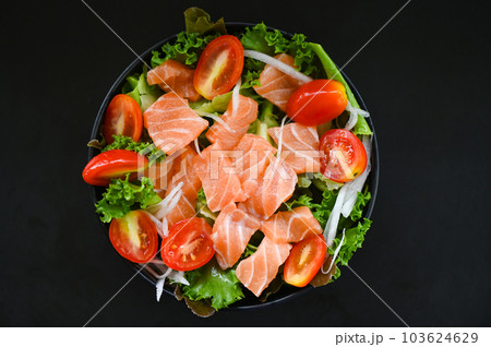 fresh raw salmon fish cooking food seafood salmon fish healthy food black background, salmon salad food salmon fillet with vegetable lettuce leaf tomato herb and spices 103624629