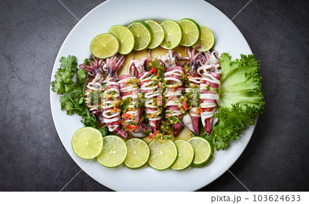 Steamed squid with lemon spicy chili and lemon sauce squid steamed with lime, Thai food seafood plate with herb and spices - top view 103624633
