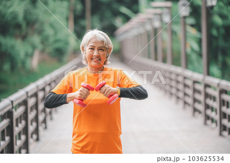 white-haired elderly person exercising in the park early in the morning. 103625534