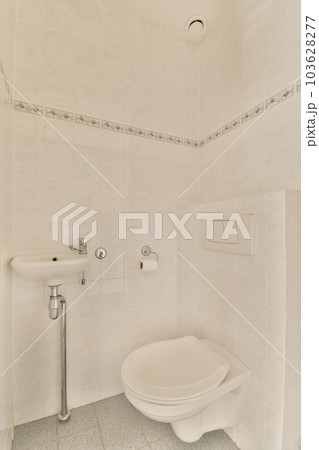 a white toilet in a bathroom with tile flooring and wall - to - wall tiles on the walls behind it 103628277