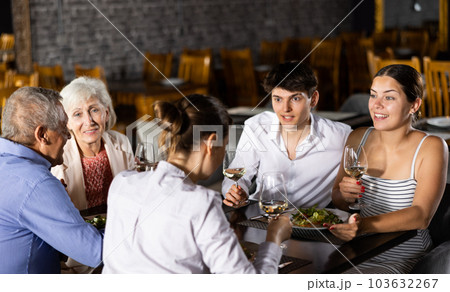 Large family, company of spouses in restaurant, eat, celebrate important event, communicate. Large family, company of spouses in restaurant, eat, celebrate important event, communicate. 103632267