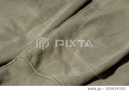 Lints on green sweater. Before cleaning and collected fluff lint. Closeup Pilled Clothes. Old used Clothes with lint pilling. Restoration of old damaged care. Repairing fabric textile reducing Lints on green sweater. Before cleaning and collected fluff lint. Closeup Pilled Clothes. Old used Clothes with lint pilling. Restoration of old damaged care. Repairing fabric textile reducing 103634183