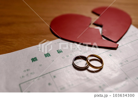 離婚届と結婚指輪と真っ二つに割れたハート　ハートブレイク 103634300