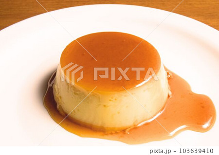 おいしそうなプリンからカラメルソースがしたたる皿に出した瞬間 おいしそうなプリンからカラメルソースがしたたる皿に出した瞬間 103639410