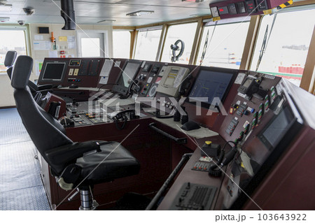 Navigational bridge on big cargo ship. Wheelhouse on vessel. ECDIS, radar. 103643922