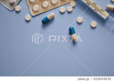 pills, thermometer and pill packs on a blue background, medication, medical workers day, medical care, banner for the hospital, a place for text pills, thermometer and pill packs on a blue background, medication, medical workers day, medical care, banner for the hospital, a place for text 103644658