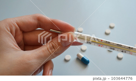 mercury thermometer in hand on a blue background, medication, medical workers day, medical care, banner for hospital mercury thermometer in hand on a blue background, medication, medical workers day, medical care, banner for hospital 103644776