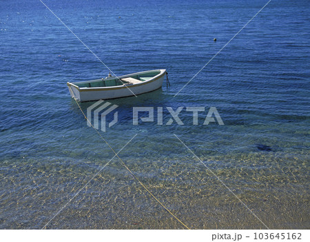エーゲ海の入り江に係留された小さな手漕ぎボートと青い海 103645162