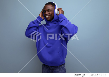 25 year old young American man with big white wireless headphones in front of copy space 103646286