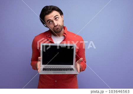 smart european young guy with chic black hair shows promotional offer on blank screen 103646563